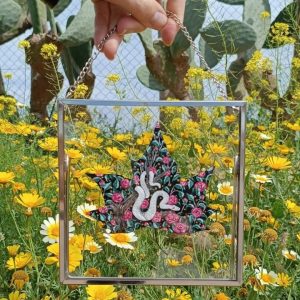 Marco metalico con fondo de cristal y una hoja pintada a mano